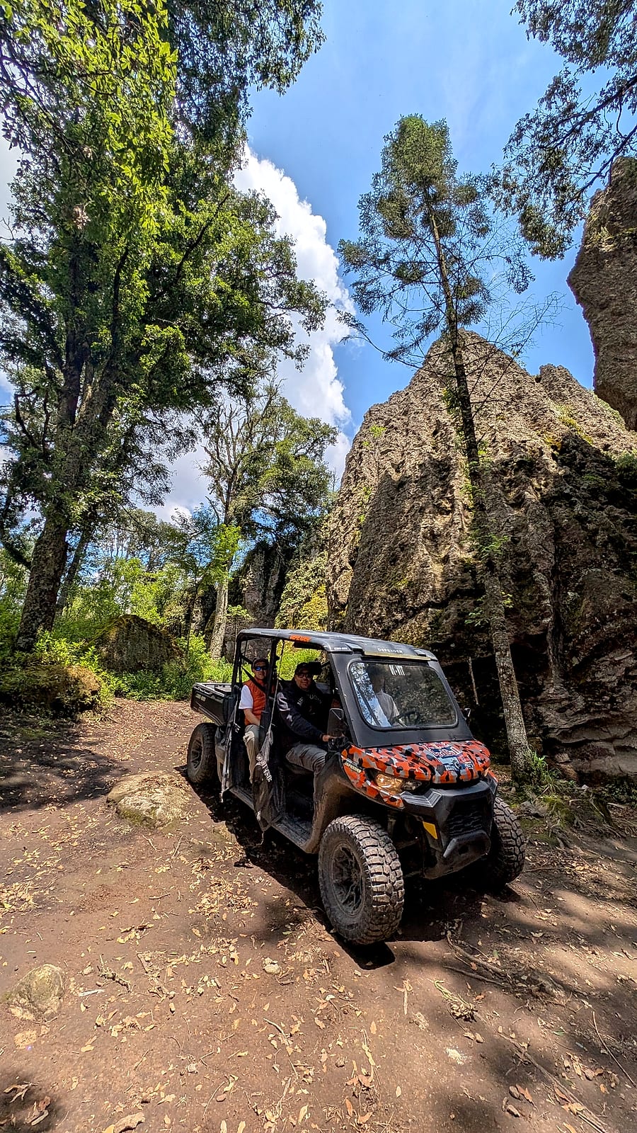 Recorrido en RZR por un sendero del bosque entre formaciones de roca y oyameles.